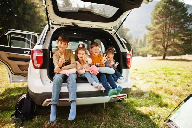 quatre enfants souriants dans un coffre de voiture